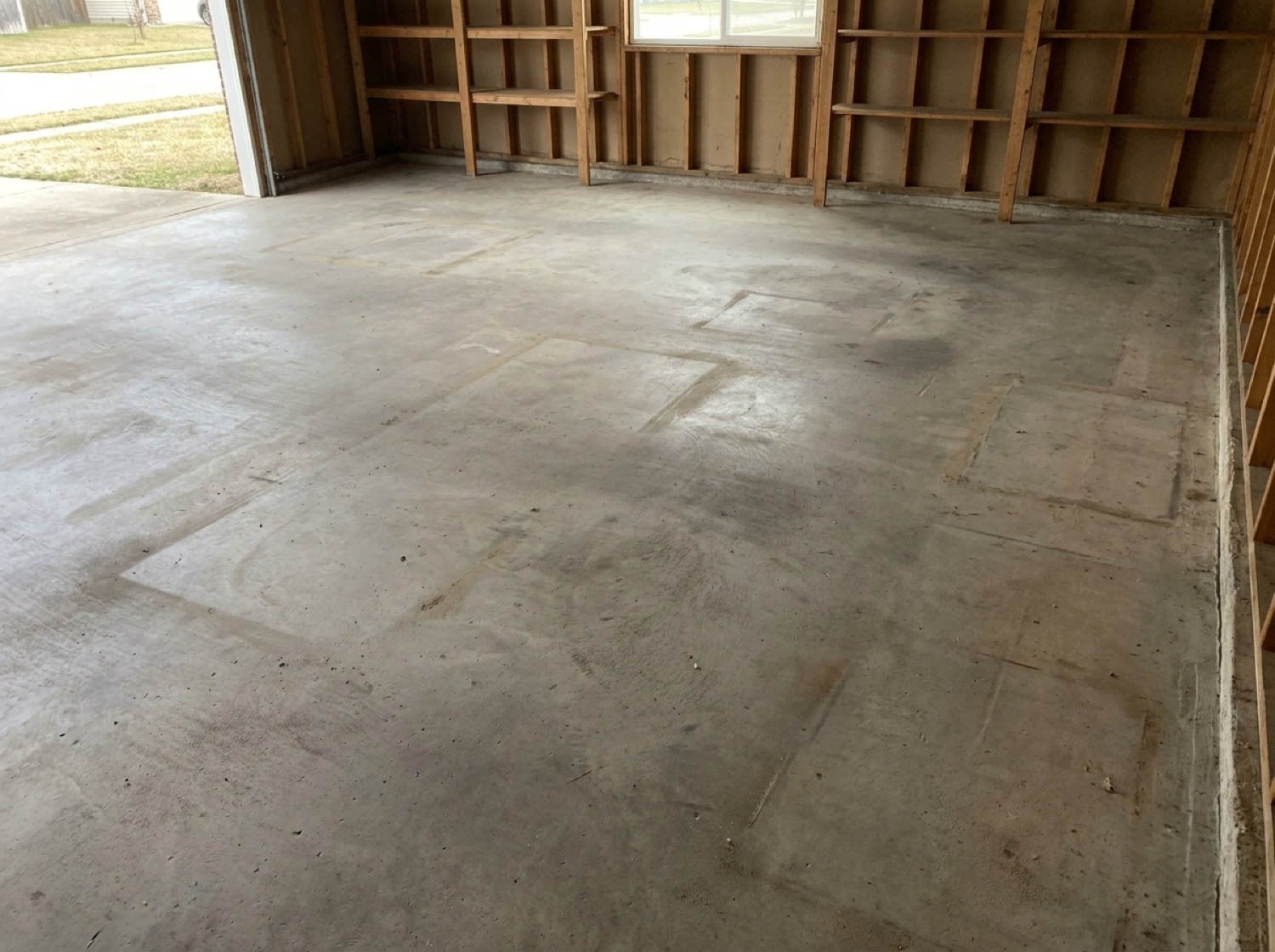 An emptied suburban garage with a swept concrete floor after a cleanout