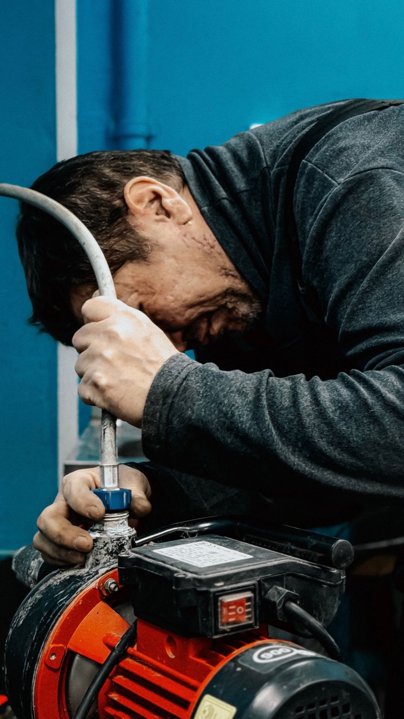 A plumber working on a shut-off valve